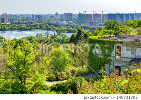 View of city skyline by the river with greenery and old building in the foreground during a sunny day View of city skyline by the river with greenery and old building in the foreground during a sunny day 140731792