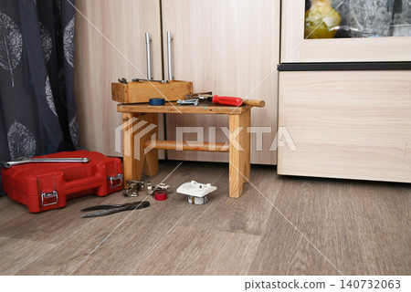 Tools and a small wooden table in a room with a cabinet and a curtain Tools and a small wooden table in a room with a cabinet and a curtain 140732063