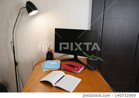Workspace with laptop, notebook, and papers on bed during the afternoon in a simple room setting Workspace with laptop, notebook, and papers on bed during the afternoon in a simple room setting 140732069