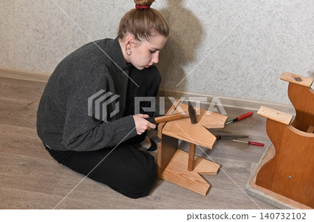woman fixing a chair with staple woman fixing a chair with staple 140732102