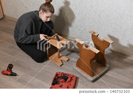 woman fixing a chair with staple 140732103