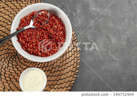 Tasty brown rice with vegetables served on grey table, flat lay. Space for text Tasty brown rice with vegetables served on grey table, flat lay. Space for text 140732404