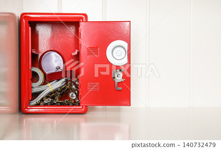 Open red steel safe with money and jewelry on shelf. Space for text 140732479