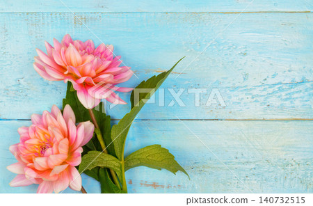 summer background. dahlias and a canvas on a blue wooden background. art. space for a text summer background. dahlias and a canvas on a blue wooden background. art. space for a text 140732515