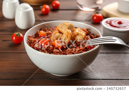 Delicious brown rice in bowl on wooden table Delicious brown rice in bowl on wooden table 140732657