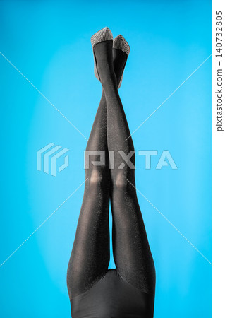 Woman wearing black tights and stylish shoes on blue background, closeup of legs Woman wearing black tights and stylish shoes on blue background, closeup of legs 140732805