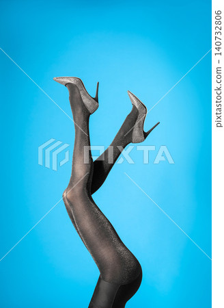 Woman wearing black tights and stylish shoes on blue background, closeup of legs Woman wearing black tights and stylish shoes on blue background, closeup of legs 140732806