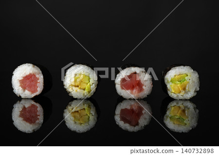 Delicious sushi rolls on black mirror surface Delicious sushi rolls on black mirror surface 140732898