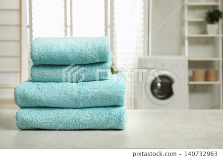 Stack of clean towels on table in laundry room. Space for text Stack of clean towels on table in laundry room. Space for text 140732963