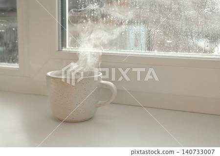 Cup of hot drink near window on rainy day. Space for text Cup of hot drink near window on rainy day. Space for text 140733007