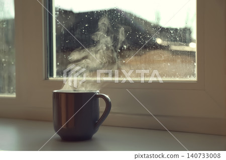 Cup of hot drink near window on rainy day. Space for text Cup of hot drink near window on rainy day. Space for text 140733008