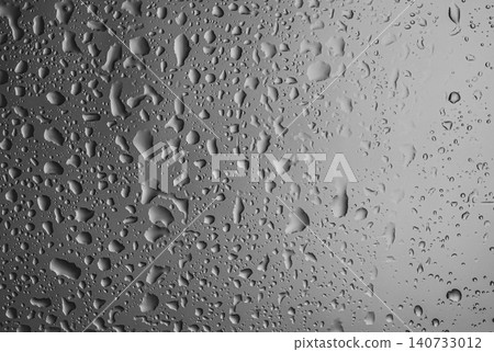 Rain drops on glass against grey background Rain drops on glass against grey background 140733012