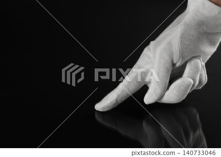 Woman checking cleanliness of black surface, closeup Woman checking cleanliness of black surface, closeup 140733046