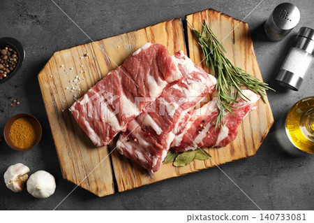 Raw ribs with herbs and spices on grey table, flat lay Raw ribs with herbs and spices on grey table, flat lay 140733081