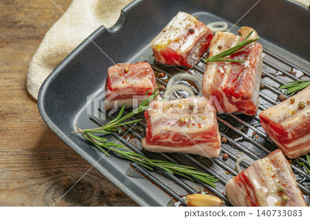 Grill pan with raw ribs and seasonings on wooden table, closeup 140733083
