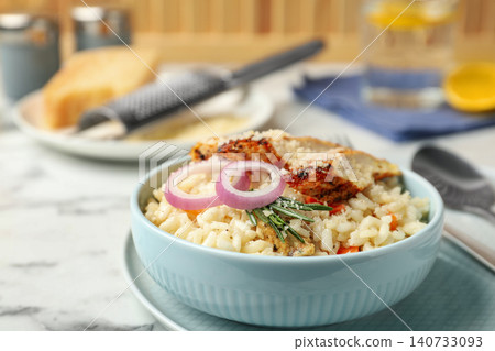 Delicious chicken risotto served in bowl on table Delicious chicken risotto served in bowl on table 140733093