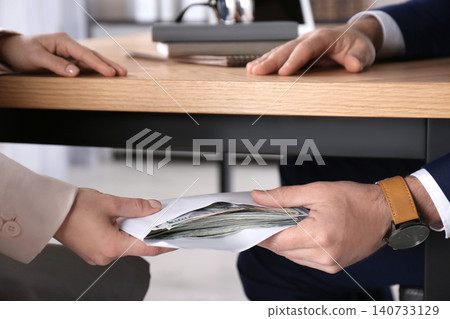 Woman giving bribe to man under table in office, closeup Woman giving bribe to man under table in office, closeup 140733129
