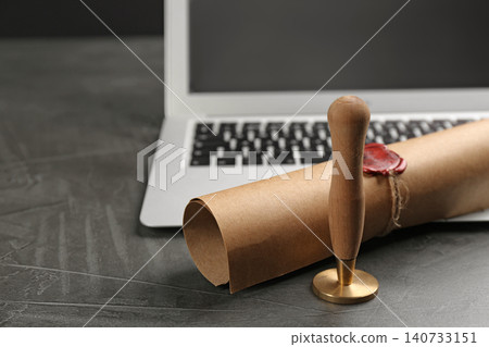Notary's public pen and sealed document near laptop on grey stone table, closeup Notary's public pen and sealed document near laptop on grey stone table, closeup 140733151