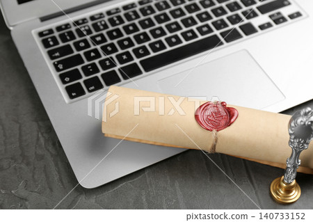 Notary's public pen and sealed document near laptop on grey stone table Notary's public pen and sealed document near laptop on grey stone table 140733152