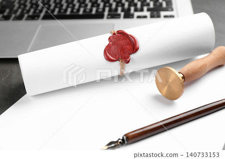 Notary's public pen and sealed document near laptop on grey stone table 140733153