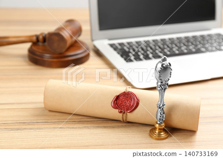 Notary's public pen and sealed document near laptop on wooden table Notary's public pen and sealed document near laptop on wooden table 140733169