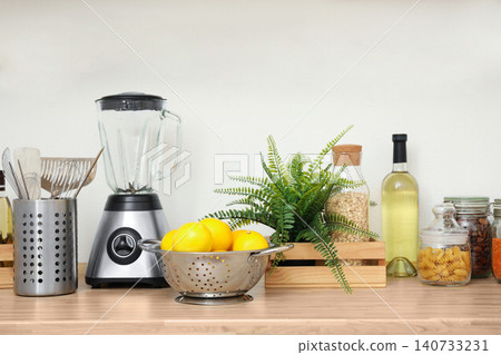 Wooden countertop with appliances and products near white wall. Kitchen interior idea Wooden countertop with appliances and products near white wall. Kitchen interior idea 140733231
