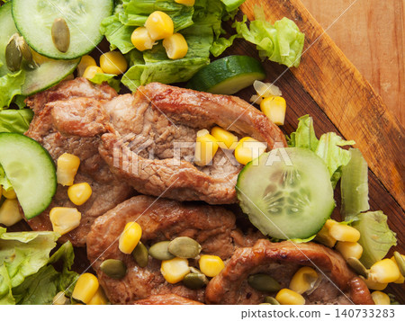 Juicy fried pork tenderloin steaks with sweet corn, green lettuce cucumbers salad and pumpkin seeds Juicy fried pork tenderloin steaks with sweet corn, green lettuce cucumbers salad and pumpkin seeds 140733283