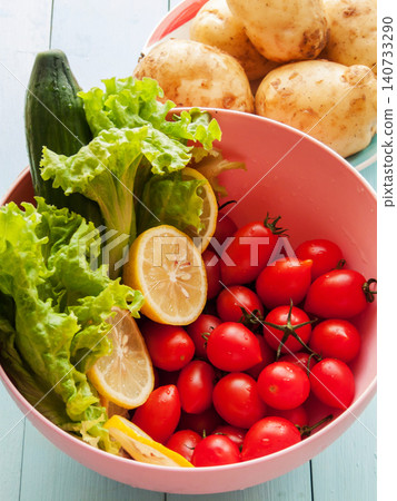 Red ripe fresh cherry tomatoes, green lettuce, potatoes and cucumber in bowl, healthy vegetables Red ripe fresh cherry tomatoes, green lettuce, potatoes and cucumber in bowl, healthy vegetables 140733290
