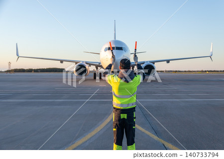 Airplane marshalling at the airport. Passenger aircraft meeting Airplane marshalling at the airport. Passenger aircraft meeting 140733794