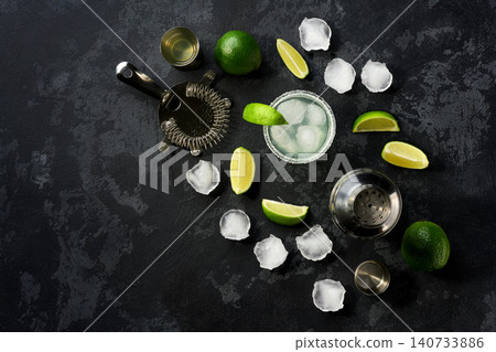 Refreshing summer alcoholic cocktail margarita with crushed ice and lime, on a black table, top view. Refreshing summer alcoholic cocktail margarita with crushed ice and lime, on a black table, top view. 140733886