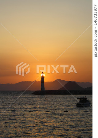 Seascape at sunshine. Lighthouse and sailings on the coast. Seaside town of Turgutreis and spectacular sunshine Seascape at sunshine. Lighthouse and sailings on the coast. Seaside town of Turgutreis and spectacular sunshine 140733977