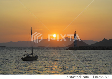 Seascape at sunshine. Lighthouse and sailings on the coast. Seaside town of Turgutreis and spectacular sunshine Seascape at sunshine. Lighthouse and sailings on the coast. Seaside town of Turgutreis and spectacular sunshine 140733978
