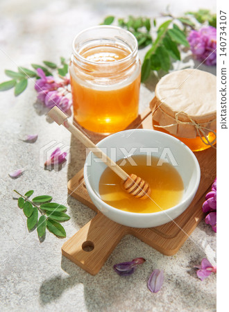 Natural honey in bowls and jars with robinia flowers Natural honey in bowls and jars with robinia flowers 140734107