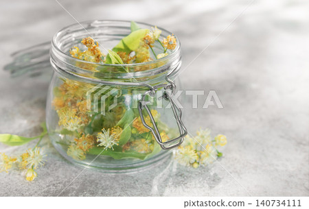 Linden blossoms filling glass jar for herbal medicine Linden blossoms filling glass jar for herbal medicine 140734111