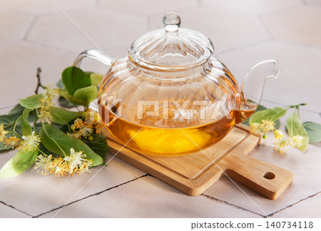 Glass teapot brewing fresh linden flower herbal tea Glass teapot brewing fresh linden flower herbal tea 140734118