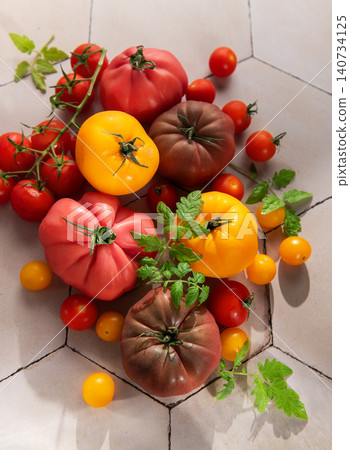 Colorful heirloom tomatoes and cherry tomatoes on tile Colorful heirloom tomatoes and cherry tomatoes on tile 140734125