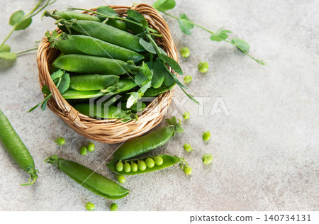 Fresh green peas pods in a wicker basket Fresh green peas pods in a wicker basket 140734131