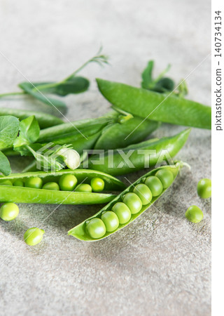 Fresh green peas in pods on stone surface Fresh green peas in pods on stone surface 140734134