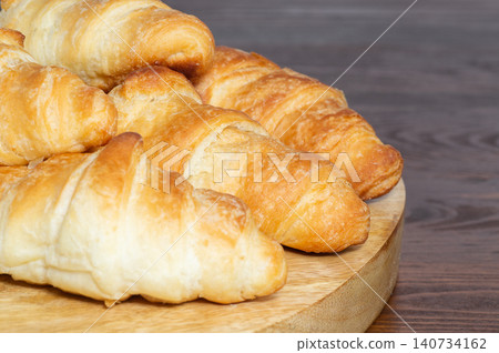 Mini croissants on a wooden background. Homemade butter croissants Mini croissants on a wooden background. Homemade butter croissants 140734162