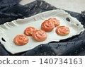 Rose-shaped piped cookies, pink icing, and an elegant plate. 140734163