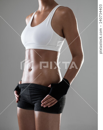 Woman, six pack with body and kickboxing for fitness, strong with muscle and sweat from workout on grey background. Boxing, self defense training and athlete for sports, exercise and power in studio Woman, six pack with body and kickboxing for fitness, strong with muscle and sweat from workout on grey background. Boxing, self defense training and athlete for sports, exercise and power in studio 140734403