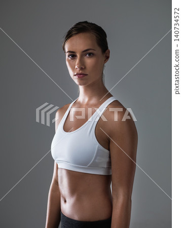 Woman, serious in portrait and confident for fitness, strong and determined with sweat from workout on grey background. Body, endurance and athlete for sports, exercise with pride and power in studio Woman, serious in portrait and confident for fitness, strong and determined with sweat from workout on grey background. Body, endurance and athlete for sports, exercise with pride and power in studio 140734572