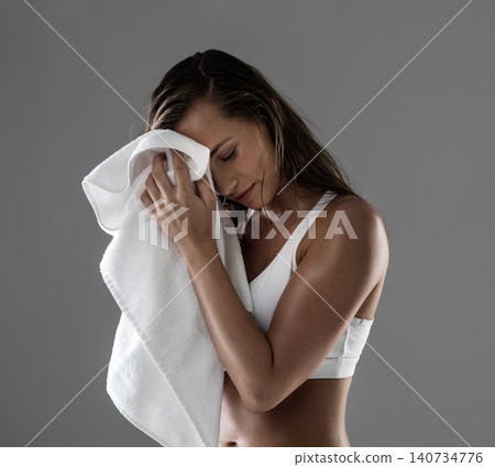 Woman, towel and sweat from workout exercise in studio for physical activity challenge, performance or grey background. Female person, endurance and gym fitness for wellness, training or mockup space Woman, towel and sweat from workout exercise in studio for physical activity challenge, performance or grey background. Female person, endurance and gym fitness for wellness, training or mockup space 140734776