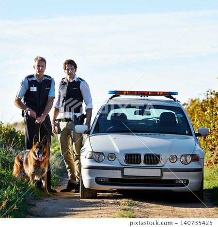 Policeman, dog and car in field to search at crime scene or robbery for safety, law enforcement and evidence. Detective, investigation and uniform in outdoor working at countryside with gravel road Policeman, dog and car in field to search at crime scene or robbery for safety, law enforcement and evidence. Detective, investigation and uniform in outdoor working at countryside with gravel road 140735425