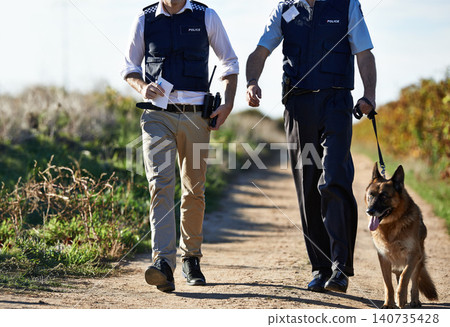 Policeman, dog and walk in field for search in crime scene or robbery for evidence, safety and law enforcement. Detective, investigation and uniform in outdoor work at countryside with gravel road Policeman, dog and walk in field for search in crime scene or robbery for evidence, safety and law enforcement. Detective, investigation and uniform in outdoor work at countryside with gravel road 140735428