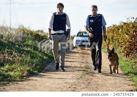 Detective, dog and walk in field for robbery or crime scene with car for search, safety and law enforcement. Policeman, investigation and uniform in outdoor working at countryside with gravel road Detective, dog and walk in field for robbery or crime scene with car for search, safety and law enforcement. Policeman, investigation and uniform in outdoor working at countryside with gravel road 140735429