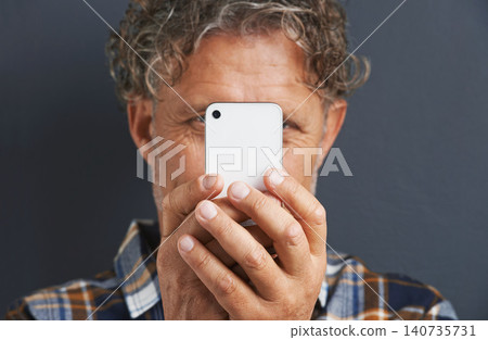 Mature, man and capture a photo with phone in studio and learning about photography on dark background. Smartphone, recording or filming a video for post online to social media for memory of picture 140735731