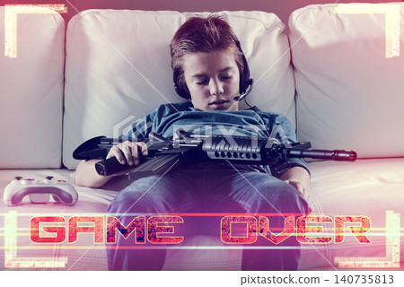 Tired, kid and gaming in home at night with overlay of video game in competition with virtual gun, skill or violence. Esports, graphic or child sleep after playing in battle with electronics weapon Tired, kid and gaming in home at night with overlay of video game in competition with virtual gun, skill or violence. Esports, graphic or child sleep after playing in battle with electronics weapon 140735813