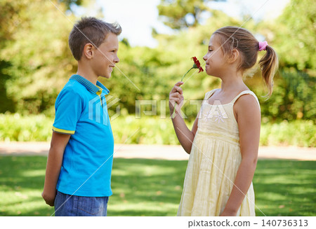 Children, friends and flower gift or outdoor connection with love kindness or young care, bonding or innocent. Boy, girl and smile at backyard garden for smell plant or summer holiday, play or park Children, friends and flower gift or outdoor connection with love kindness or young care, bonding or innocent. Boy, girl and smile at backyard garden for smell plant or summer holiday, play or park 140736313