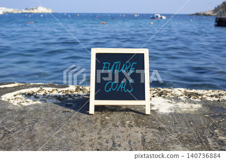 Future Goals symbol. White blackboard with Concept words Future Goals. Beautiful sea background. Business and Future Goals concept. Copy space. Future Goals symbol. White blackboard with Concept words Future Goals. Beautiful sea background. Business and Future Goals concept. Copy space. 140736884